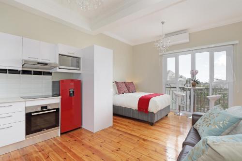 een keuken en een woonkamer met een rode koelkast bij Vesper Apartments in Kaapstad