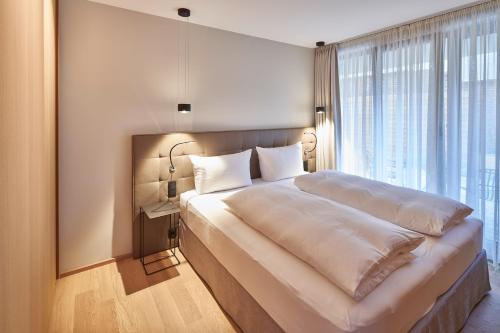 a bedroom with a large bed with a large window at Hotel Misan in Norderney