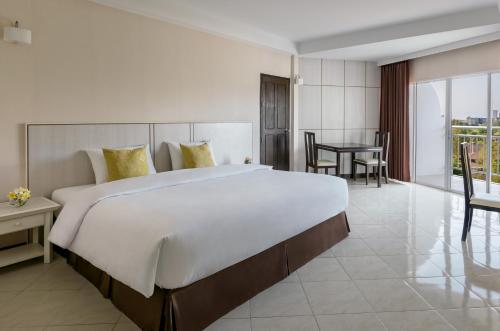 a large bedroom with a large bed and a table at Seapine Beach Golf and Resort Hua Hin in Hua Hin