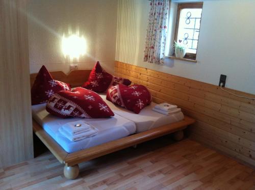 a room with a bed with red pillows on it at Appartements Hexahüsle in Wald am Arlberg