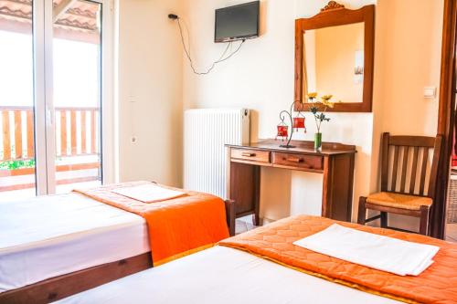 a room with two beds and a desk and a mirror at Villa Panagiotis Chania in Daratso