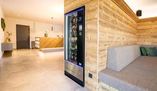 uma sala de estar com um refrigerador de bebidas numa parede em Hotel Das Essigmanngut em Anif