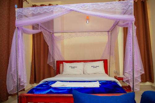 Postel nebo postele na pokoji v ubytování Kilimanjaro White House Hotel