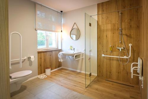 a bathroom with a shower and a toilet and a sink at Villa Bałtycka in Gdańsk