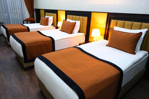 a group of three beds in a hotel room at Dimen Hotel in Bursa
