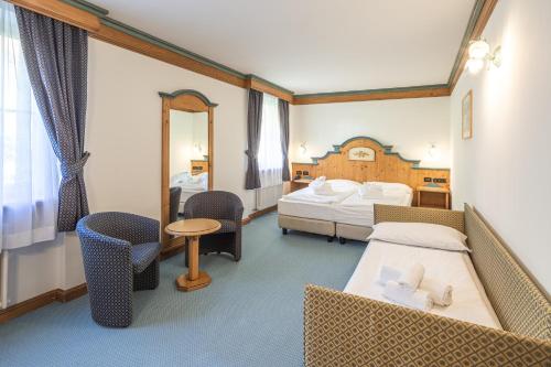 a hotel room with two beds and a mirror at Hotel Bellavista in Cavalese