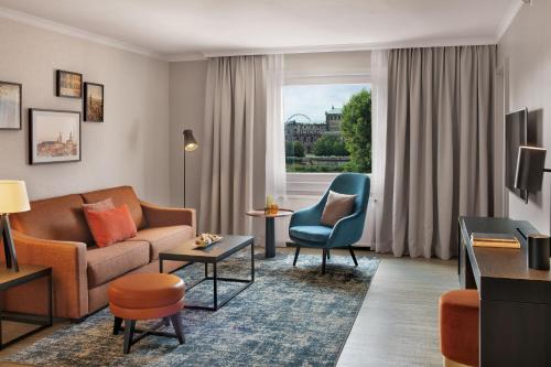 
a living room filled with furniture and a window at Bilderberg Bellevue Hotel Dresden in Dresden
