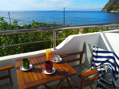 een tafel op een balkon met uitzicht op de oceaan bij Calypso in Agia Roumeli