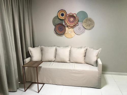 a living room with a couch and plates on the wall at APT 2/4 LUXO IBEROSTATE in Praia do Forte