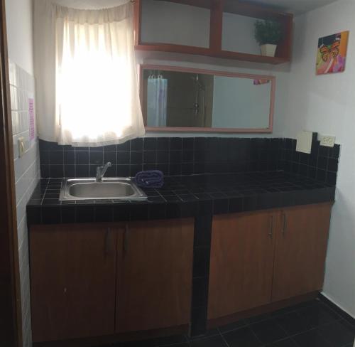 a kitchen counter with a sink and a window at Dotan's Boutique Guesthouse - By The Beach! in Tel Aviv