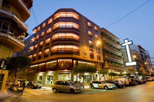 Un grand bâtiment avec des voitures garées devant lui dans l'établissement Hotel El Churra, à Murcie