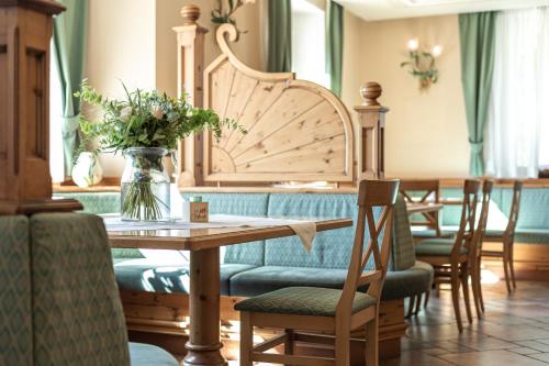 a table and chairs with a vase of flowers on it at Hotel Bellavista in Cavalese