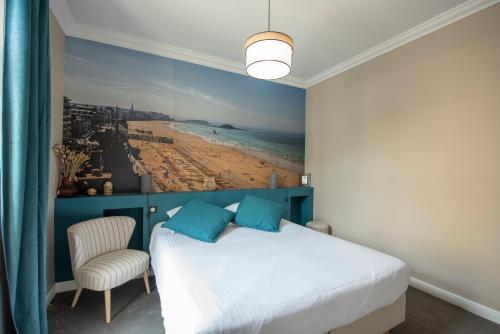 1 dormitorio con 1 cama y una pintura de playa en La Villa du Sillon, en Saint-Malo