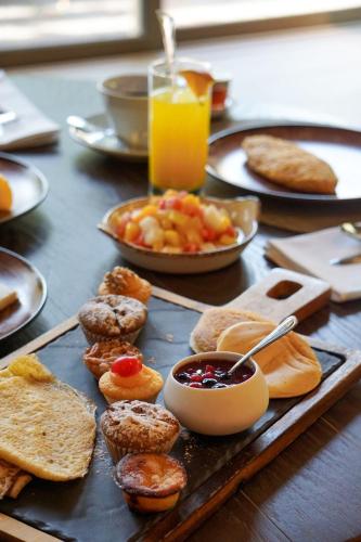 a table with a tray of food with bread and toast at Crowne Plaza Porto by IHG in Porto