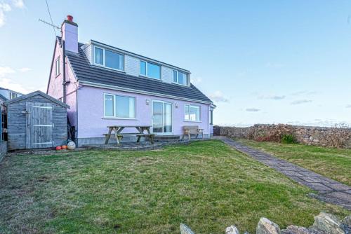 a house with a picnic table in front of it at Spin Drift in Cemaes Bay