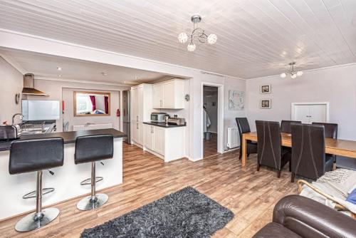 a living room with a table and chairs and a kitchen at Spin Drift in Cemaes Bay