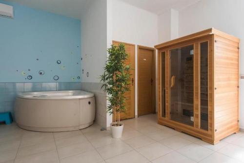 een badkamer met een bad en een potplant bij Apartments Villa Ema in Zadar