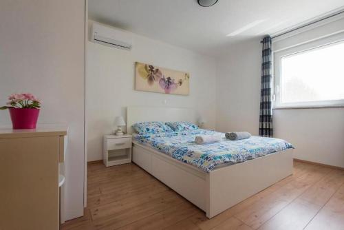 een slaapkamer met een bed en een raam bij Apartments Villa Ema in Zadar