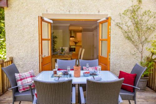 a table and chairs sitting on a patio at Bonnie Banks Cottage in Balloch