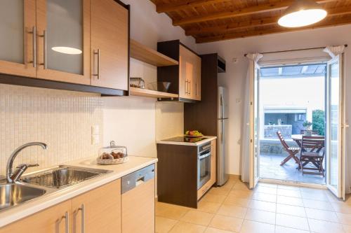 a kitchen with a sink and an open door to a patio at Sea Wind Villas and Suites in Tourlos