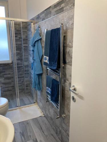 uma casa de banho com chuveiro e toalhas azuis na parede em Bacio di Dama em Milão