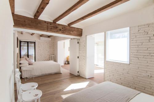 a bedroom with two beds and a brick wall at La Casa del Canal in Roquetas