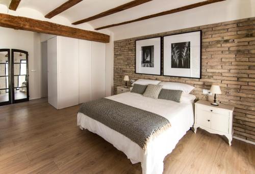 1 dormitorio con 1 cama grande y pared de ladrillo en La Casa del Canal en Roquetas
