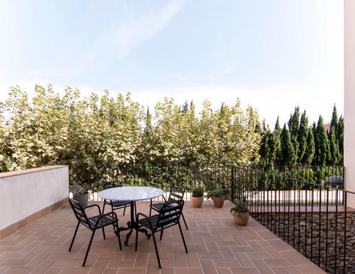 a patio with a table and chairs and trees at La Casa del Canal in Roquetas