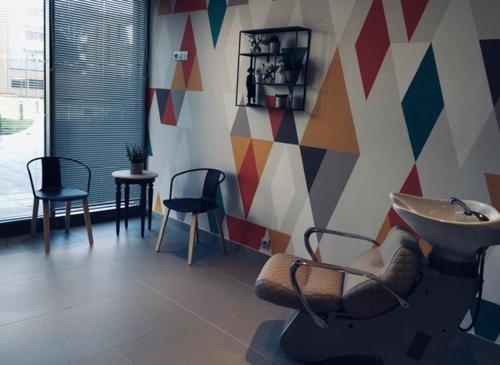 a room with chairs and a sink and a wall at Résidence Services DOMITYS La Cantate in Dunkerque