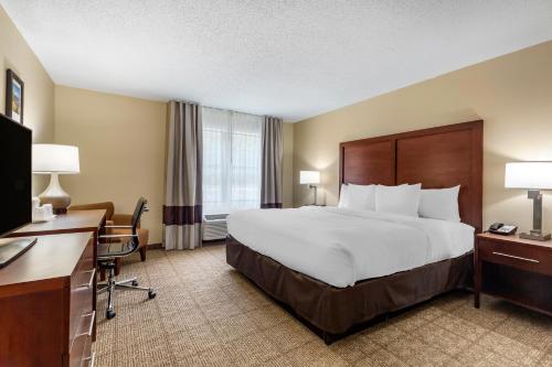a hotel room with a large bed and a desk at Comfort Inn Danvers - Boston North Shore in Danvers