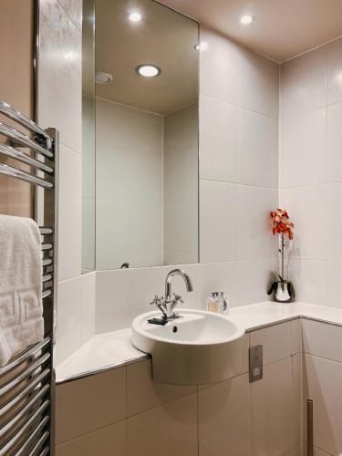 a white bathroom with a sink and a shower at Apartment 11 Popeshead Court in York