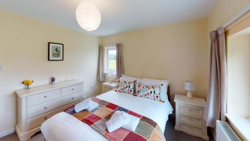 En eller flere senge i et værelse på Woodlands Cottage