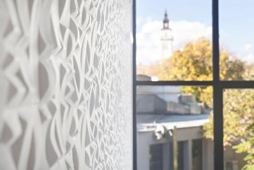 a window with a view of a building at Kombinat Rooms City Center in Novi Sad