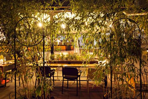 a patio with chairs and plants in a building at Kombinat Rooms City Center in Novi Sad