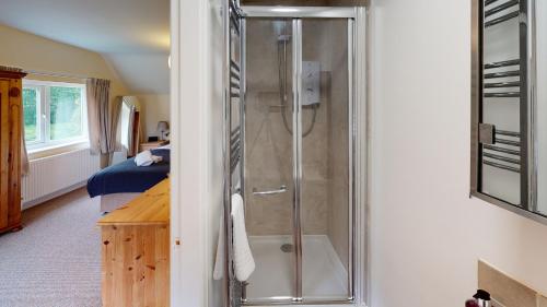 y baño con ducha y puerta de cristal. en Woodlands Cottage en York