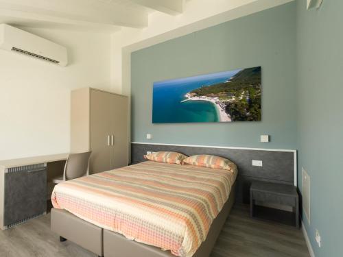 a bedroom with a bed with a painting on the wall at Le Terre di Maluk in Monte San Vito