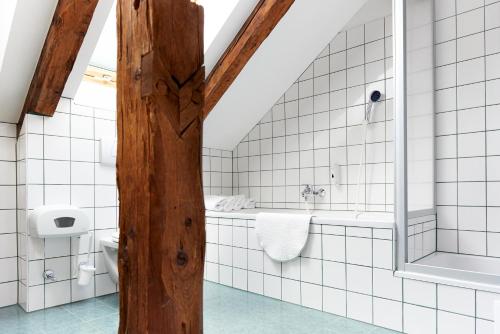 a bathroom with a tub and a toilet and a sink at Hotelchen Döllacher Dorfwirtshaus in Großkirchheim