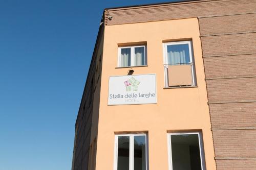 a building with a sign on the side of it at Hotel & Wellness Stella Delle Langhe in Govone