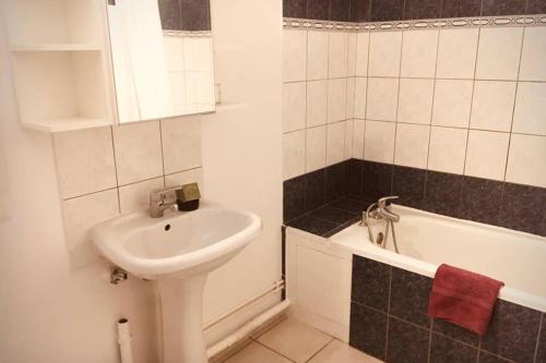 a bathroom with a sink and a bath tub at Au bord de l eau in Pesmes