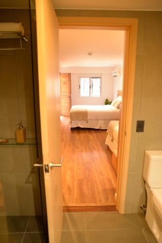 a room with a bedroom with a bed and a bathroom at TAS D VIAJE Suites - Hostel Boutique in Punta del Este