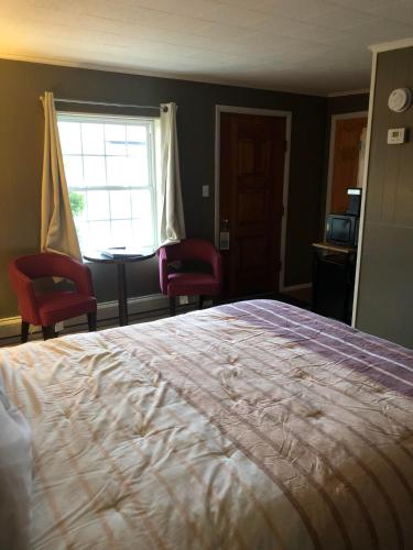 a bedroom with a large bed with two chairs and a window at Oakes Oramel Inn in Oramel