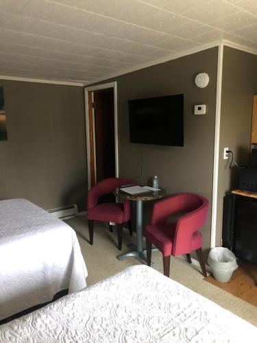 a hotel room with a bed and a desk with chairs at Oakes Oramel Inn in Oramel
