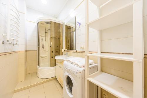 een witte badkamer met een wasmachine en een wastafel bij Centre 911 flat in Kiev