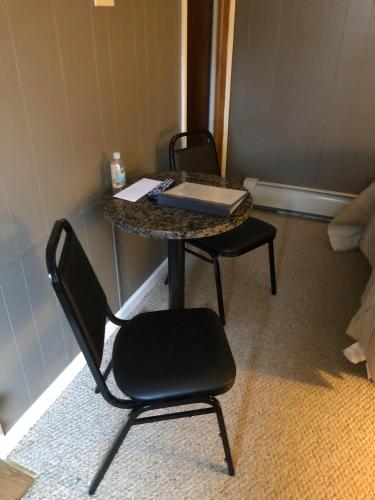 a table with a chair and a table with a book on it at Oakes Oramel Inn in Oramel