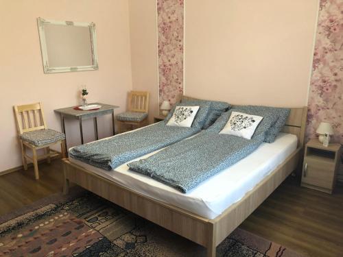 1 dormitorio con 1 cama, 2 sillas y espejo en Emese vendégház, en Mezőpeterd