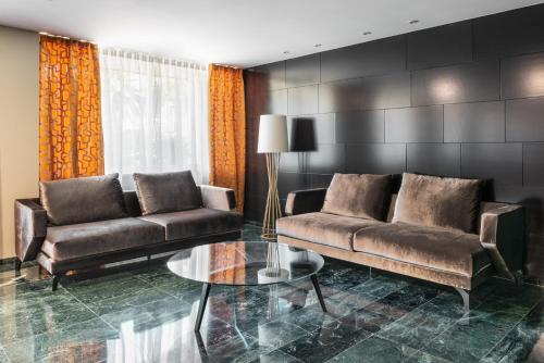 a living room with two couches and a glass table at Eurostars Atlántico in A Coruña