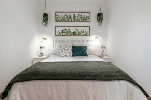 a bedroom with a large bed with two lamps at Tresor Boutique Apartment in Girona