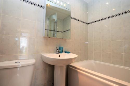 une salle de bain avec un lavabo, des toilettes et une baignoire dans l'établissement Freeland Cottage, à Dunoon