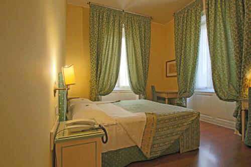 Schlafzimmer mit einem großen Bett und grünen Vorhängen in der Unterkunft Il Giardino Di Albaro in Genua