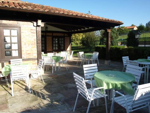 a group of tables and chairs with green tables and chairs at Hotel Siglo XVIII in Santillana del Mar